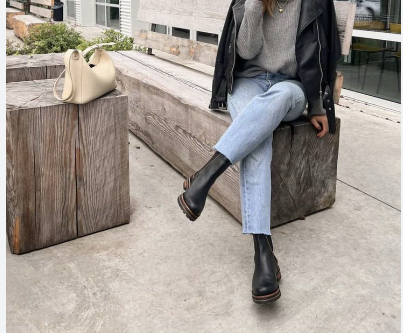woman wearing Chelsea boots, sitting crossed legged